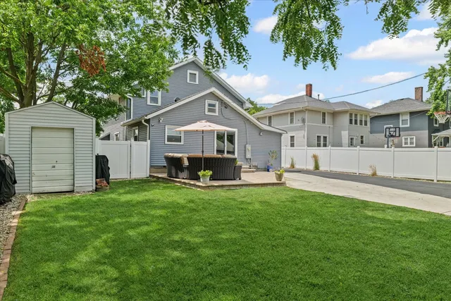 a front view of a house with a garden and trees