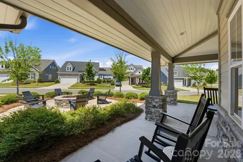 a view of a patio with lawn chairs floor to ceiling window and outdoor kitchen
