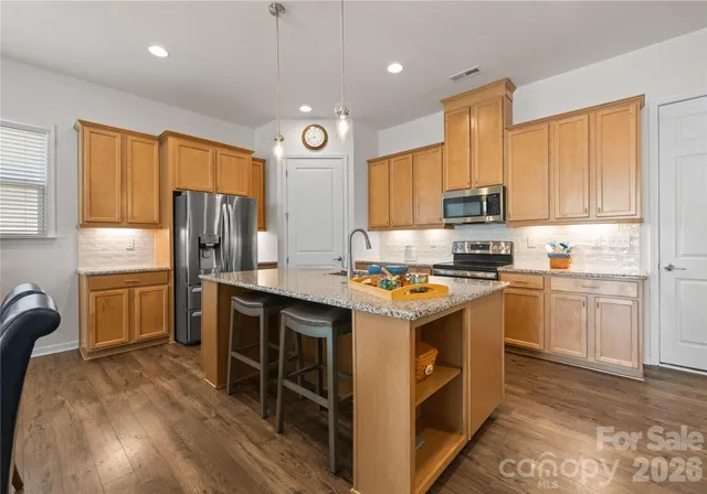 a kitchen with stainless steel appliances granite countertop a stove refrigerator sink and cabinets