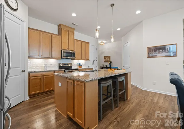 a kitchen with kitchen island granite countertop a sink appliances and cabinets