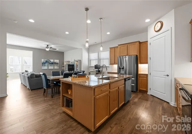 a kitchen with stainless steel appliances kitchen island granite countertop a large center island and a refrigerator