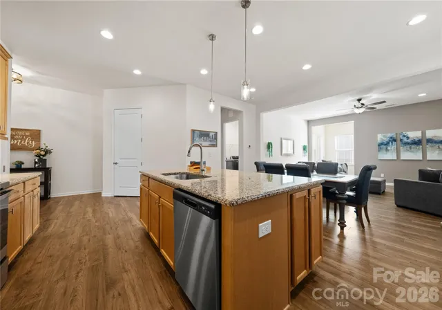 a kitchen with stainless steel appliances granite countertop sink stove top oven and cabinets