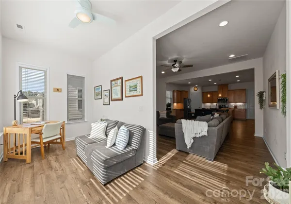 a living room with furniture and a dining table with wooden floor