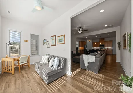 a living room with furniture and a dining table with wooden floor