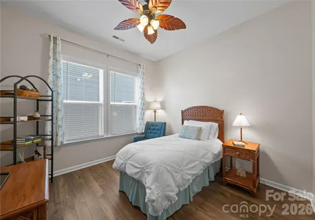 a bedroom with a bed a dresser next to a window