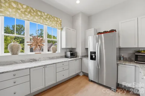 a kitchen with stainless steel appliances granite countertop a refrigerator and a sink