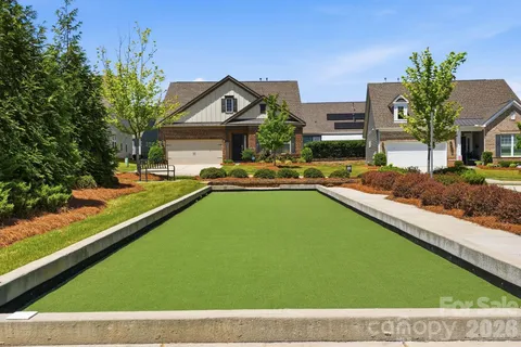 a view of swimming pool with outdoor seating and trees in the background