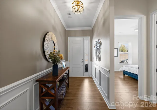 a view of a hallway with wooden floor and a chandelier