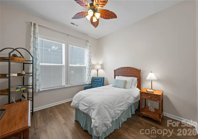 a bedroom with a bed a dresser next to a window