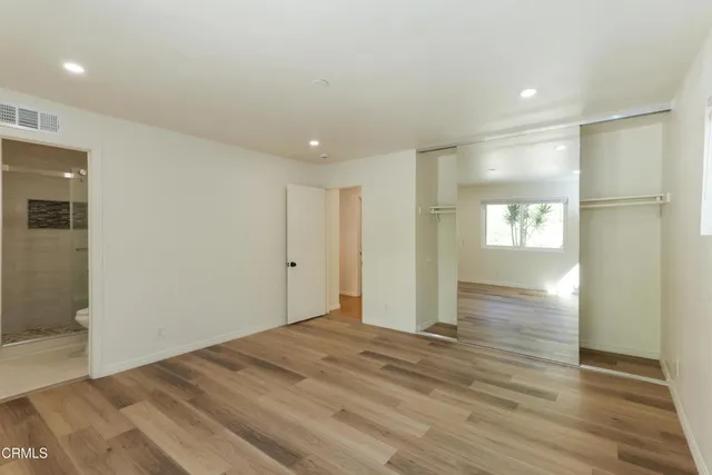 an empty room with wooden floor and window