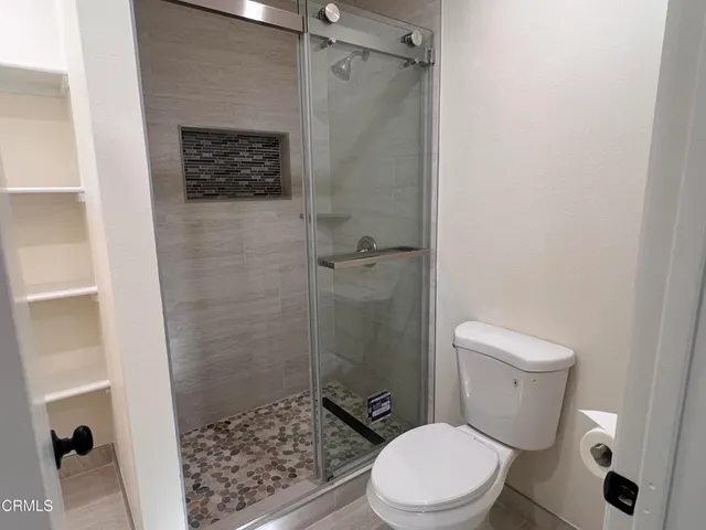 a white toilet sitting next to a bathroom sink and a shower