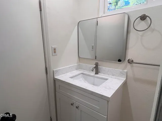 a bathroom with a granite countertop sink and a mirror