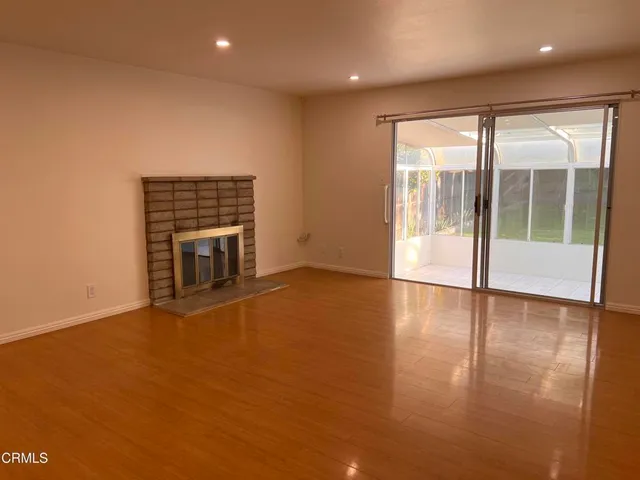 an empty room with wooden floor and fireplace
