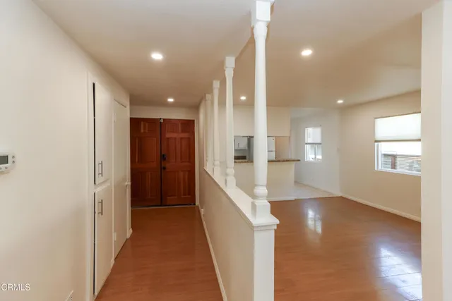 a view of a hallway with wooden floor and windows
