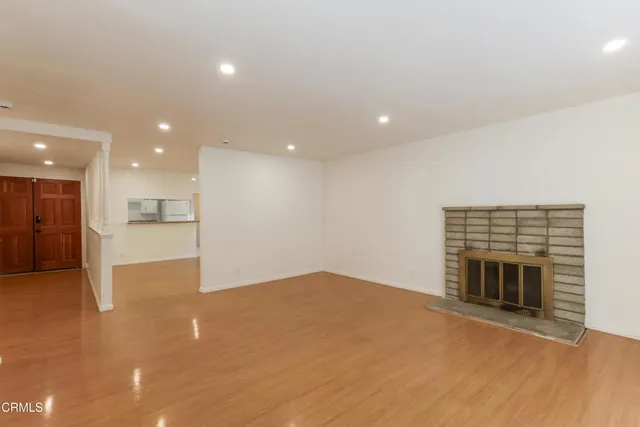 a view of an empty room with a fireplace and a window