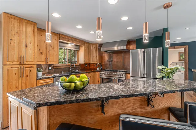 a kitchen with kitchen island granite countertop a sink a counter top space and living room view