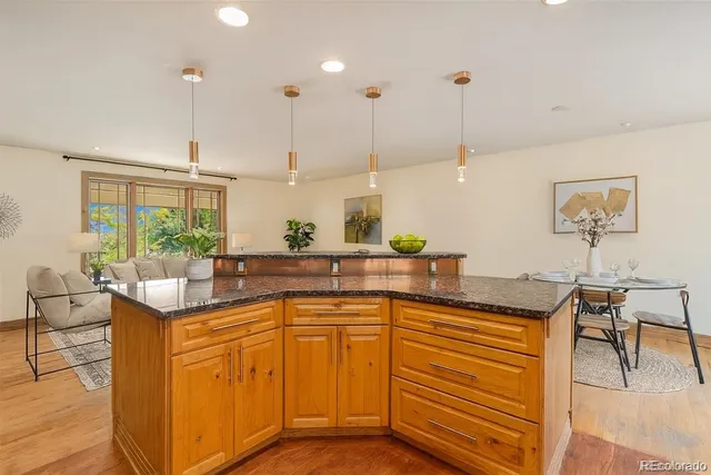 a kitchen with stainless steel appliances granite countertop a sink a stove and a wooden floors