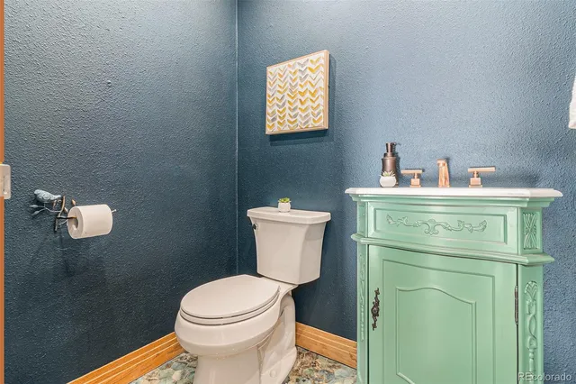 a bathroom with a toilet a sink and mirror