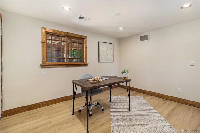 a view of a workspace with furniture and wooden floor
