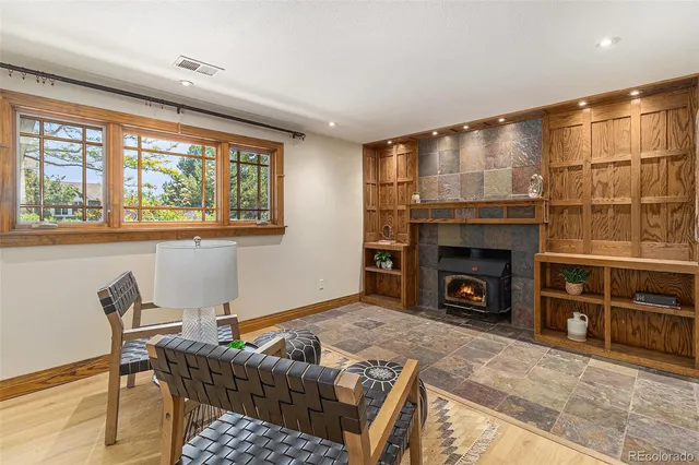 a living room with furniture a fireplace and a floor to ceiling window