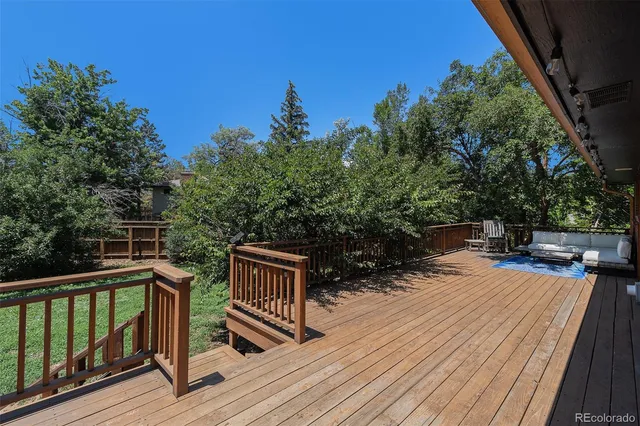 a balcony with wooden floor and outdoor seating
