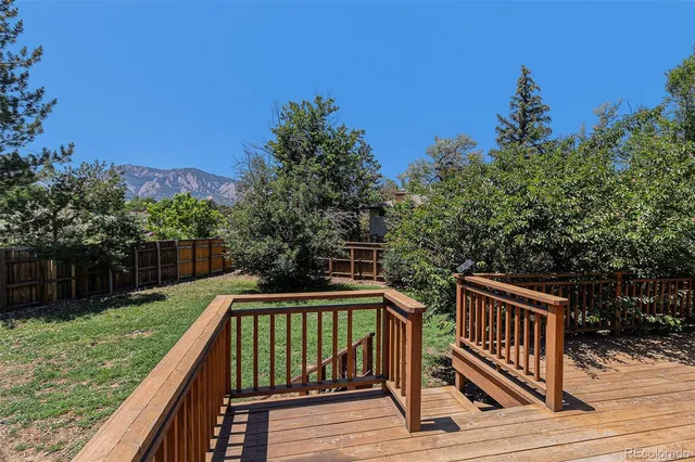 a view of deck with two chairs and wooden fence