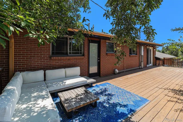 a backyard of a house with wooden floor chairs and a fire pit