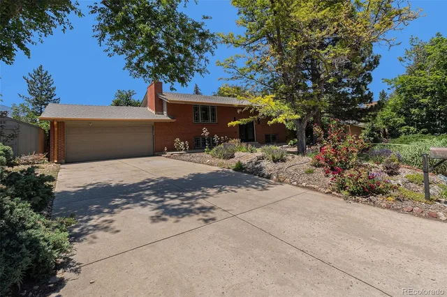 a front view of a house with yard and trees