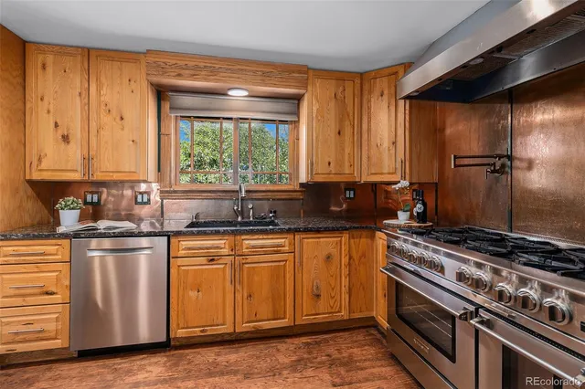 a kitchen with stainless steel appliances granite countertop a sink stove and refrigerator