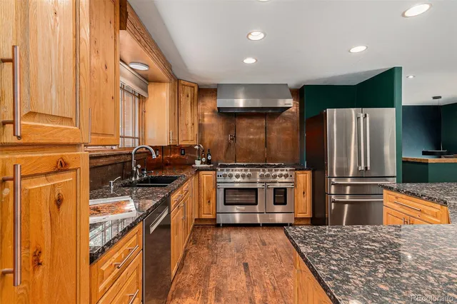 a kitchen with stainless steel appliances a stove a sink and a refrigerator