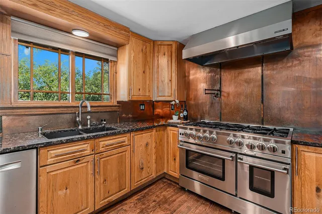 a kitchen with granite countertop a stove and a sink