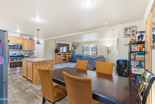 a large living room with stainless steel appliances furniture a rug and a kitchen view