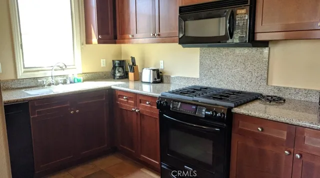 a bathroom with a granite countertop toilet and a sink