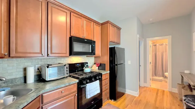 a kitchen with stainless steel appliances granite countertop a refrigerator stove top oven a sink and dishwasher