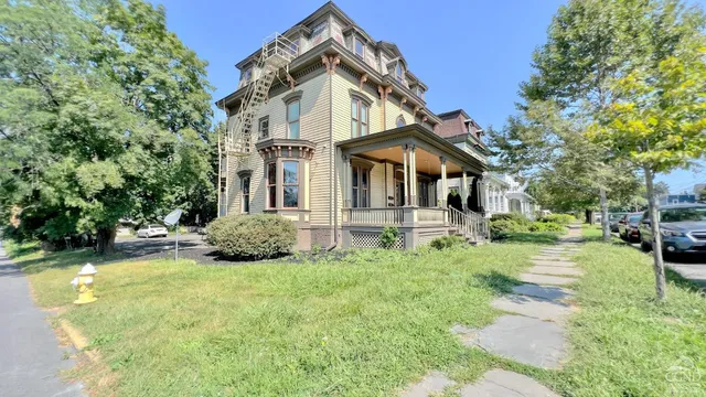 a front view of a house with yard and green space