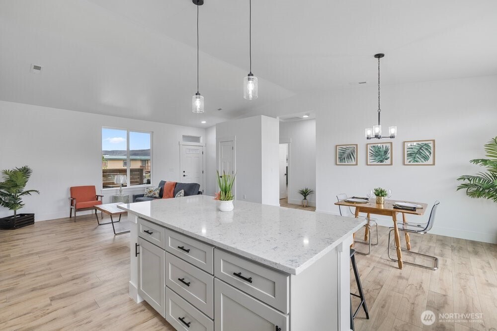 334 Spring Circle Mattawa, WA 99349 - Photo 4 of 40 a large kitchen with kitchen island a stove a dining table chairs with wooden floor