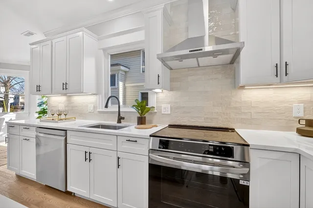 a kitchen with white cabinets and appliances