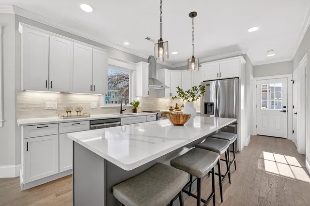 a kitchen with stainless steel appliances granite countertop a sink a stove a refrigerator and island