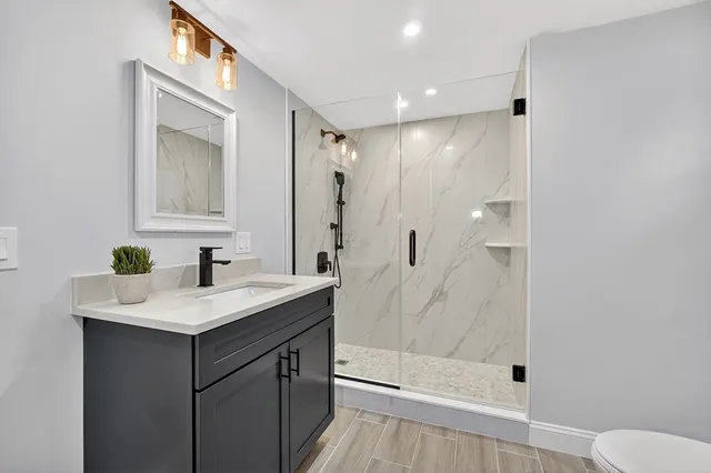 a bathroom with a sink a toilet and shower