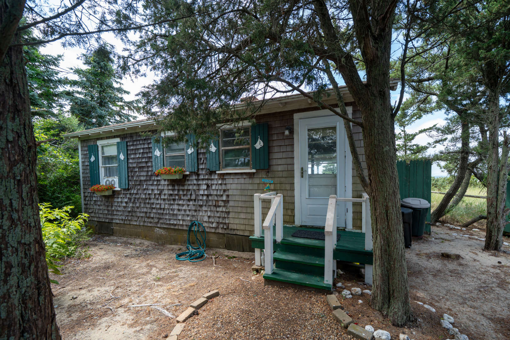 11 Beach Road Oak Bluffs, MA 02557 - Photo 4 of 18 a view of a chair and table in backyard of the house