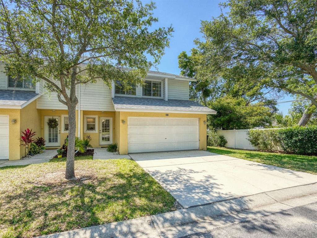 1116 Sunset Point Road, Unit 207 Clearwater, FL 33755 - Photo 1 of 1 a front view of a house with a yard and garage