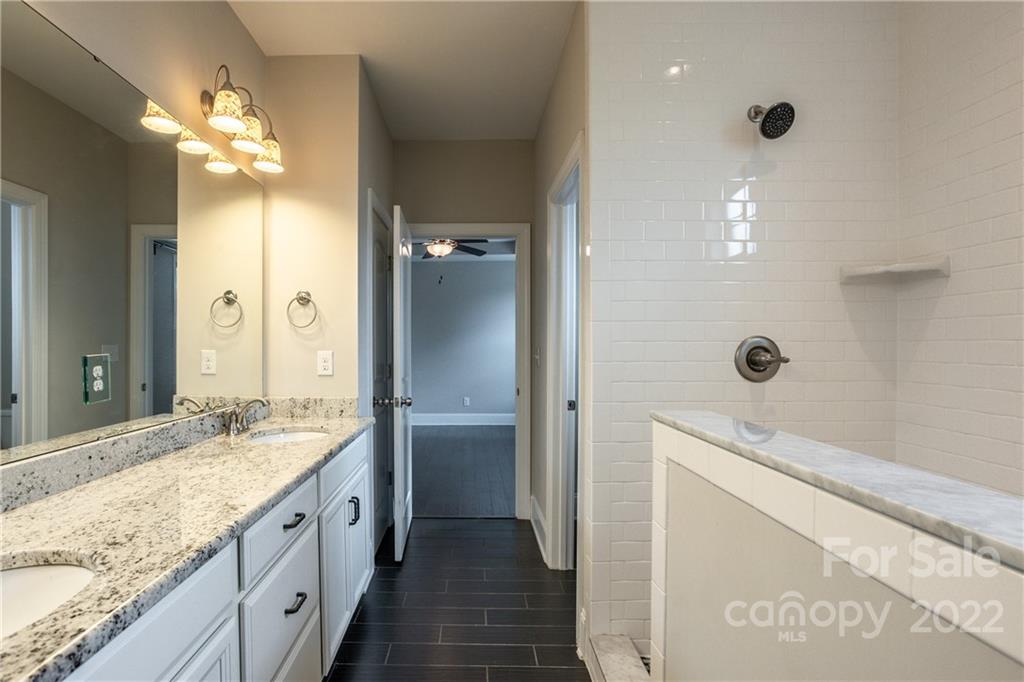 907 Ospre Lane Fort Mill, SC 29708 - Photo 17 of 39 a spacious bathroom with a granite countertop sink a mirror and a shower
