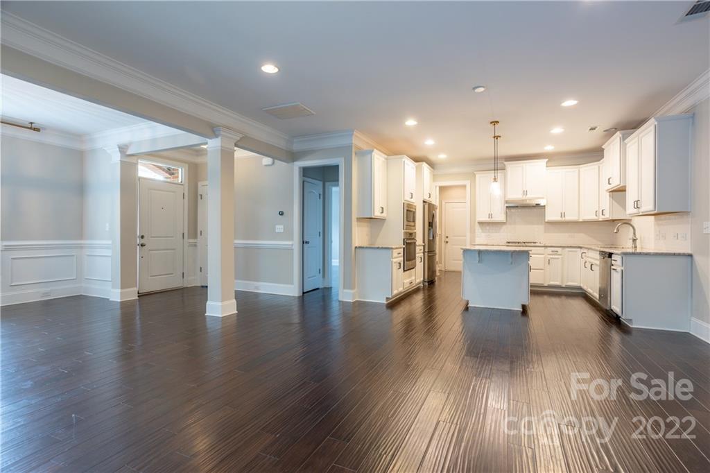 907 Ospre Lane Fort Mill, SC 29708 - Photo 10 of 39 an open kitchen with white cabinets wooden floor and stainless steel appliances