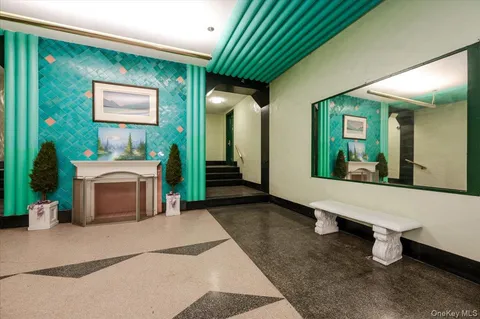 a view of a hallway with wooden floor and a bathroom