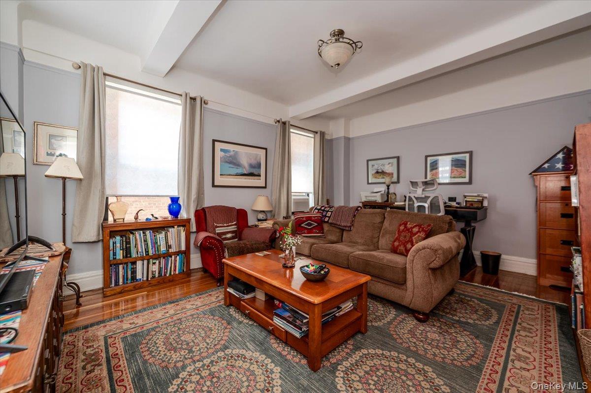 83-00 Talbot Street, Unit 2B Queens, NY 11415 - Photo 5 of 16 a living room with furniture a rug and a window