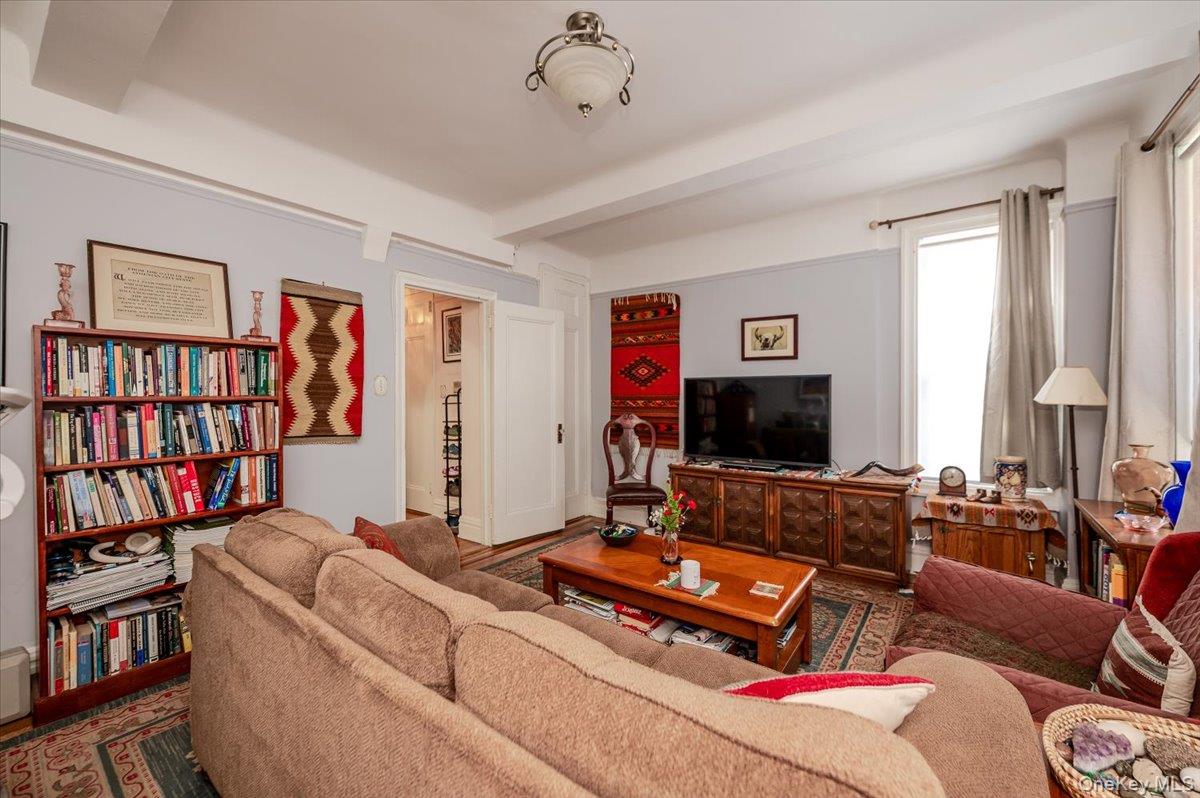 83-00 Talbot Street, Unit 2B Queens, NY 11415 - Photo 6 of 16 a living room with furniture and a flat screen tv