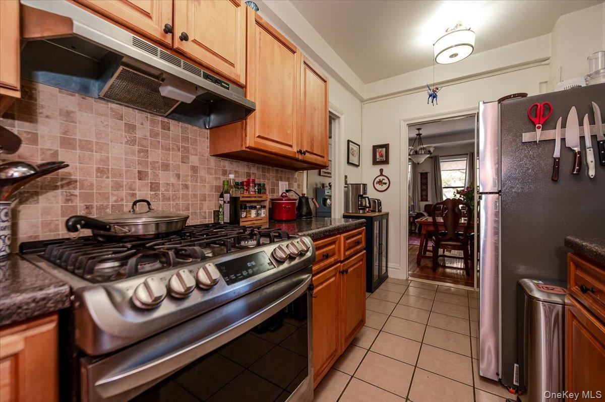83-00 Talbot Street, Unit 2B Queens, NY 11415 - Photo 10 of 16 a kitchen with stainless steel appliances granite countertop a stove and a refrigerator