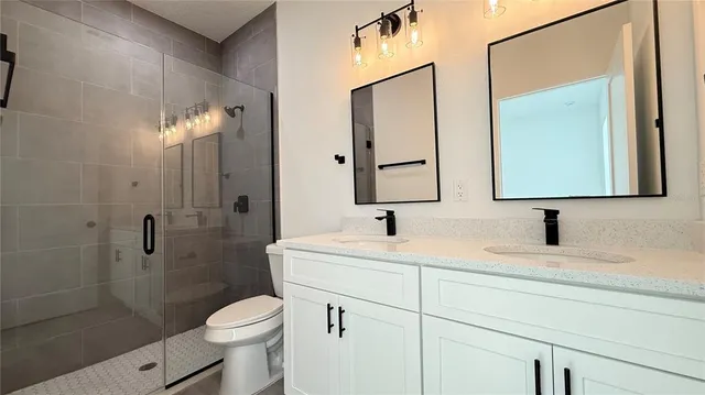 a bathroom with a sink toilet vanity and shower