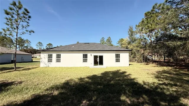 a front view of house with yard and trees around