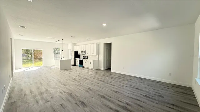 a view of empty room with wooden floor and window